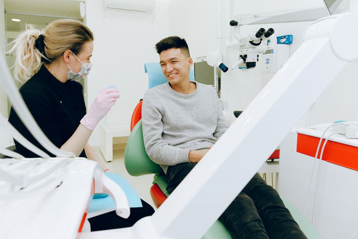 Dentista conversando com paciente no consultório